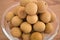 Bowl filled with an heap Dimocarpus Longan fruit on wooden background