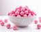 Bowl Filled With Pink Candy Balls. A white bowl is filled with pink candy balls creating