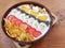 A bowl of flakes, grains, pecans, yogurt, oat, sliced strawberries and bananas