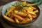 a bowl of french fries with rosemary sprigs