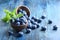 Bowl of fresh blueberries on blue rustic wooden table closeup