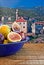 Bowl of fresh figs on rustic wooden table against village background