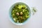 Bowl of fresh leafy green salad with olives, dill, onion and paprika