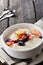 Bowl of fresh mixed berries and yogurt with farm fresh Papaya on a wooden table