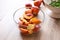 Bowl with fresh sliced peaches on wooden table