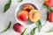 Bowl with fresh sweet peaches on light table