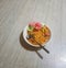 a bowl of fried rice added colorful crackers with a white bowl and a spoon