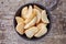 Bowl of frozen potato wedges on wood, from above