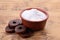 Bowl of fructose powder and fruit leather rolls on wooden table