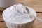 Bowl of fructose powder on wooden table, closeup