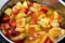 A bowl of fruit salad made of slices of bananas, strawberry, cantaloupe, apples and juice of mango and orange mixed