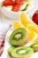 Bowl with fruit salad - pieces of orange, banana, strawberry and kiwi