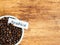 Bowl full of Arabica coffee beans over an old wooden background, copy space