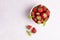 Bowl full of big bright strawberries, grey background, top view