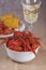 The bowl full of the crawfish with glass and corn on the background