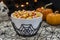 A bowl full of Halloween candy corn in a spooky setting