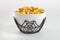 A bowl full of Halloween candy corn on a white background