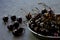 Bowl full of ripe dark large cherries with stalks on grey stone table. Organic freshly