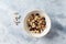 Bowl of granola with nuts,  cranberry, almonds and rasins. Sport supplements  carnitine capsules  in background.