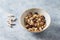 Bowl of granola with nuts,  cranberry, almonds and rasins. Sport supplements  carnitine capsules  in background.