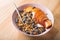 Bowl of granola with yogurt, peach slices and bluberry on a wooden table