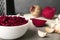 Bowl of grated fresh beets and garlic on table, closeup. Space for