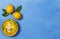 A bowl of Greek avgolemono chicken soup, with lemon and egg yolks. Top view, on a blue background with lemons, pepper mill, ladle