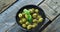 Bowl of green olives in vinegar garnished with herb