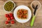 Bowl with green peas, sandwich with meat pate and tomato in plate, knife on jar with meat pate, tomates cherry on table. Top view