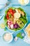 Bowl with grilled chicken meat, bulgur and fresh vegetable salad of radish, tomatoes, avocado, kale and spinach leaves