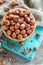 Bowl with hazelnuts on burlap and old green board.