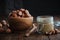 Bowl of hazelnuts, glass jar of raw organic hazelnut butter or paste on kitchen table