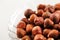 A bowl of hazelnuts on a white background