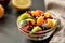 Bowl of healthy fresh fruit salad on black background