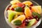 Bowl of healthy fresh fruit salad on black background