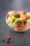 Bowl of healthy fresh fruit salad on black background