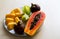 Bowl of healthy fresh fruit salad on white background. Top view. Mangosteen, papaya, carambola, jackfruit.