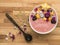 A bowl of home made yogurt with fruits, wooden background