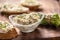 A bowl of homemade cream cheese spread with chopped chives surrounded by bread slices with spread and a bunch of freshly