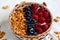 Bowl of homemade granola with yogurt and fresh berries close up