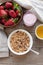 A bowl of homemade granola with yogurt and fresh strawberries on a wooden background. Healthy breakfast with green tea