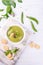 Bowl of homemade green spring pea soup topped with pumpkin seeds, croutons. On white background.