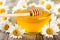 Bowl of honey with daisy flowers