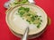 A bowl of hot porridge on a red table