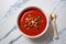 Bowl of hot tomato soup over marble background, top view photo. Italian cuisine. Generative AI