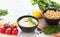 Bowl with hummus, chickpeas, lemon, cherry tomatoes and herbs on a white rustic wooden background. Middle Eastern cuisine. Backgro