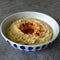 Bowl with hummus topped with olive oil and paprika