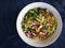 Bowl with ingredients for spring vegetables salad standing on wrinkly bluish cotton fabric