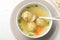 Bowl of Jewish matzoh balls soup on white wooden table