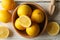 Bowl, lemons and wood juicer on background, top view